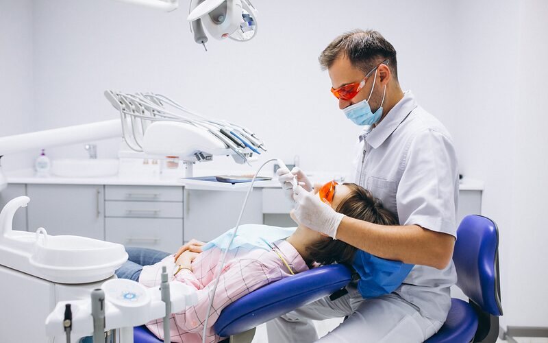 Dentista atendendo paciente no consultório